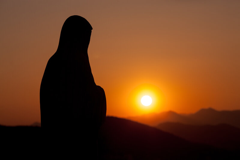 Estatua de la Virgen María iluminada por el atardecer en Medjugorje
